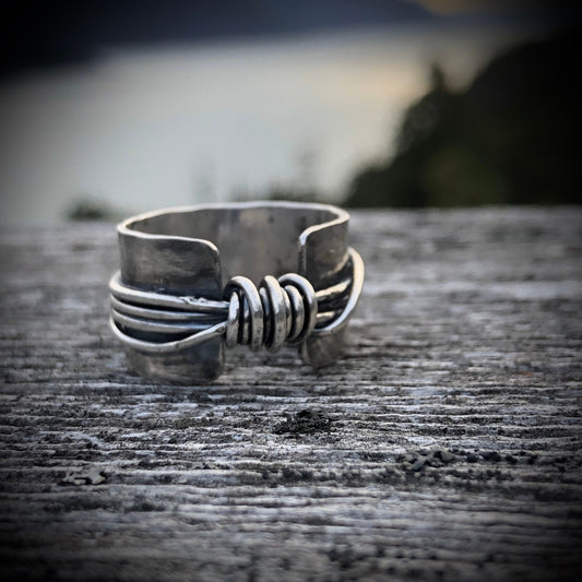 Hand made wide band sterling silver knot ring with open band.